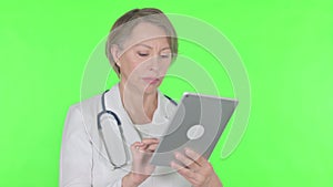 Old Female Doctor using Digital Tablet on Green Background