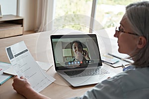 Old female hr employer hr reading cv during online job interview by video call.