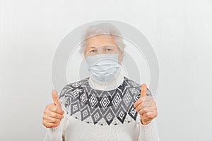 Old female model making peace or victory sign wearing medical