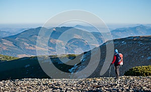 Old female tourist enjoying the open view on the mountains