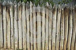 An old fence made of wooden logs, designed for defense against invaders