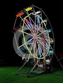 Old Ferris wheel at night, brightly illuminated