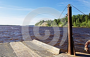 An old ferry sails along a wide Siberian river