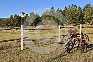 Old field cultivator by a corral fence in the Black Hills area