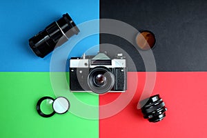 The old film camera and lenses lie on different four backgrounds