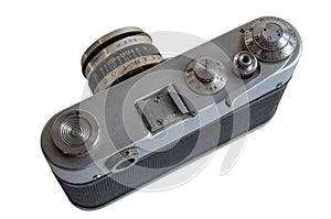 Old film camera with silver-black cast aluminum body with traces of use and scratches, with trigger cocked shutter. Isolated