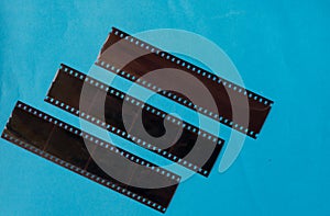 Old film negatives on a plain blue colour background