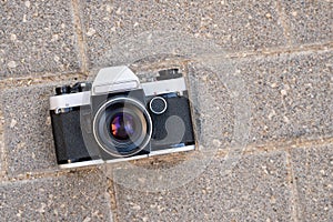 Old film photo camera lying on the pavement