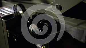 Old film projector playing in the night. Close-up of a reel with a film
