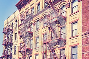 Old film retro toned photo of New York building with fire escape