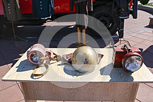 Old fire equipment, fire bronze protective helmet and miner`s lanterns on the table