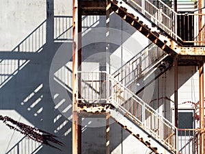 Old fire escape staircase installed on building wall.