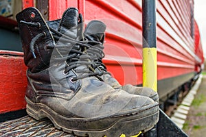 Old firefighter boots on the background of red fire train