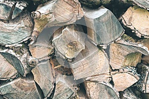 Old Firewood or fuelwood stacked by a wall. Texture woodpile