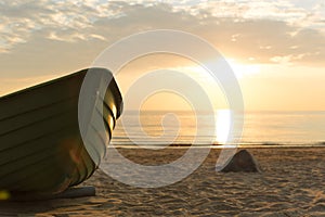 Old fisherman boat at sunset time. Sunset at the Baltic Sea Beach.