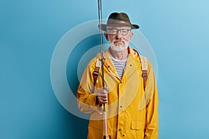 Old fisherman with fishing rod and fishing gear.