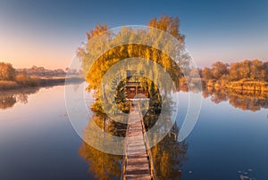 Old fisherman house and wooden pier at sunrise in autumn