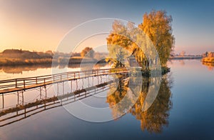 Old fisherman house and wooden pier at sunrise in autumn