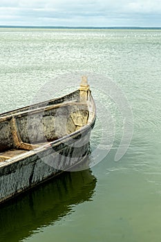 Old fisherman`s boat in a still water on a sunny summer day.