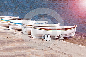 Old fisherman`s boats on white beach on warm sunset and copy spase.