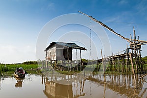 Old fisherman's house and wooden boat beside the lake