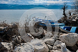 Old fishermen boats on coast of the lake of uluabat with huge mountain background.