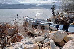 Old fishermen boats on coast of the lake of uluabat with huge mountain background.