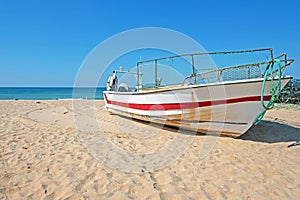 Old fishers boat on the beach in Armacao de Pera in the Algarve Portugal