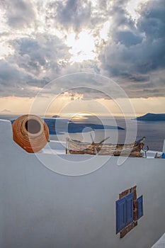 Old fishing boat against sunset on Santorini island in Greece