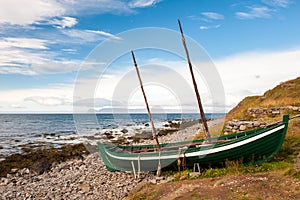 Old fishing boat, boat of the Vikings on the ocean shore, Iceland