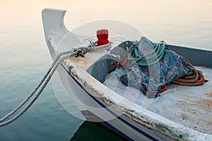 Old Fishing Boat Docked at Dawn. Small Wooden Boat on the Water Tide With Ropes. Sunrise in the Harbor and Sea.