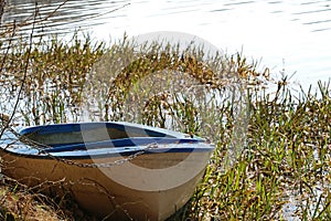 Old fishing boat locked with a padlock and chain in the reeds