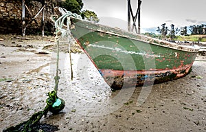 Old fishing boat is moored on beach at low tide. photo
