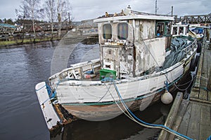 Old fishing boat moored on the river pier