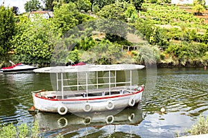 Old fishing boat next to small motor boats for leisure activities in the betanzos river.A coruna, Spain