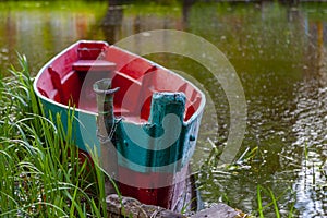 Old fishing boat tied by a chain near the shore