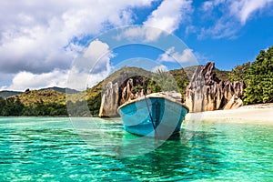 Old fishing boat on Tropical beach at Curieuse island Seychelles