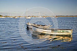 Old fishing boats reflected in calm water during Summer sunset