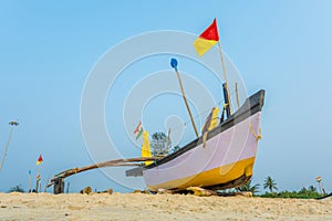 old fishing boats in the sand on the ocean in India on blue sky background