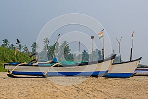 old fishing boats in the sand on the ocean in India on blue sky background