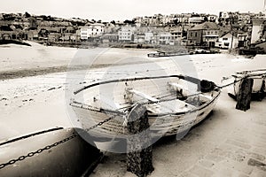 Old fishing rowing boat abandoned in the harbour in Cornwall