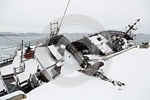 Old fishing ship in disrepair sank at pier