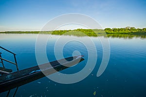 Old fishing wooden boat in a calm lake water