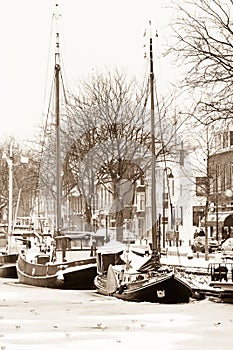 Old fishingboats in ice and snow - sepia