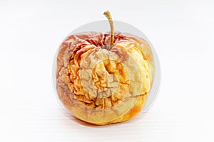 old flabby rotten apple on a white background