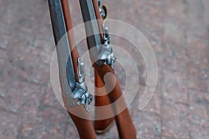 Old flintlock rifle with a wooden butt close-up on a blurred background