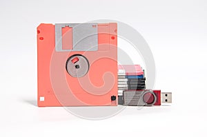 Old floppy disk and flash drive put on white background.