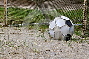 Old football on flooring sand, Concept sport equipment is lacking.