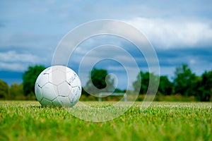 Old football on green grass in Stadium