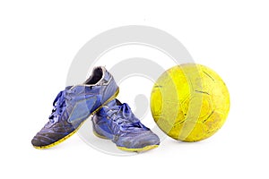 Old football shoes damaged and old dirty yellow futsal ball on white background football object isolated